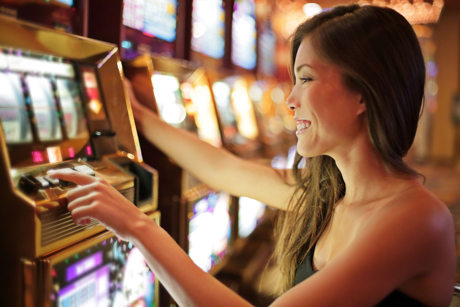 Young lady pressing button the activate the slot machine