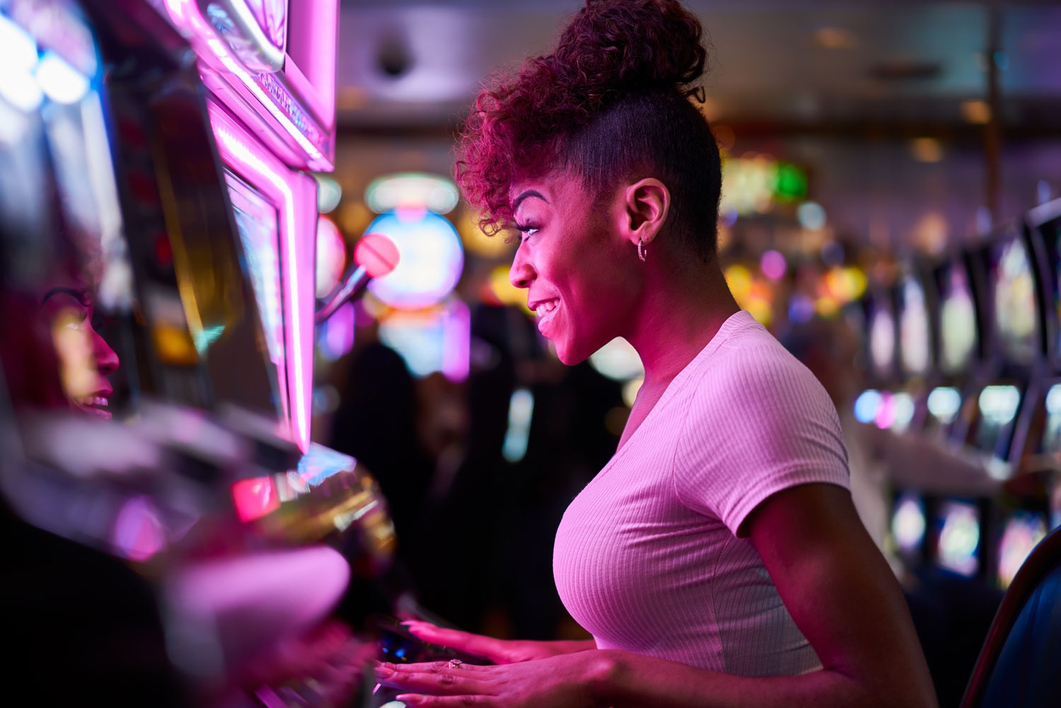 Promotions - woman anxiously awaiting the results, while playing one of the many slot machines available