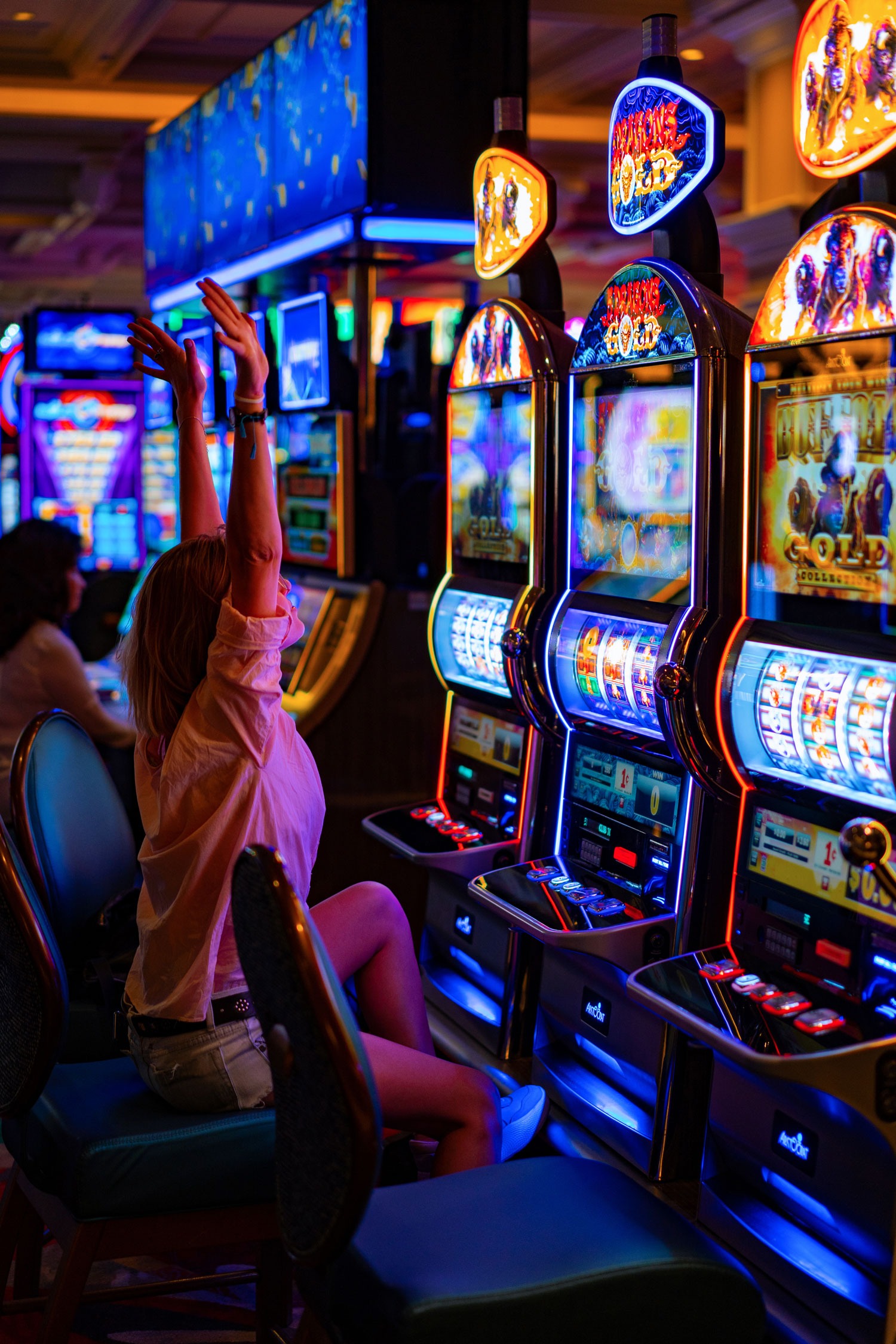 High Limit Room - Woman celebrating a big win on a slot machine